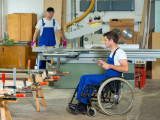 disabled worker in wheelchair in a carpenter's workshop